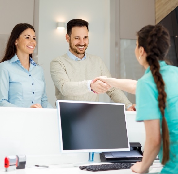 patient shaking hands with receptionist